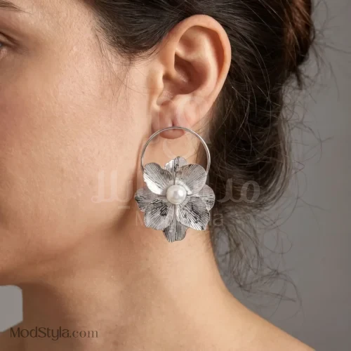 نمای نزدیک گل برجسته و مروارید گوشواره آویز نقره‌ای زنانه