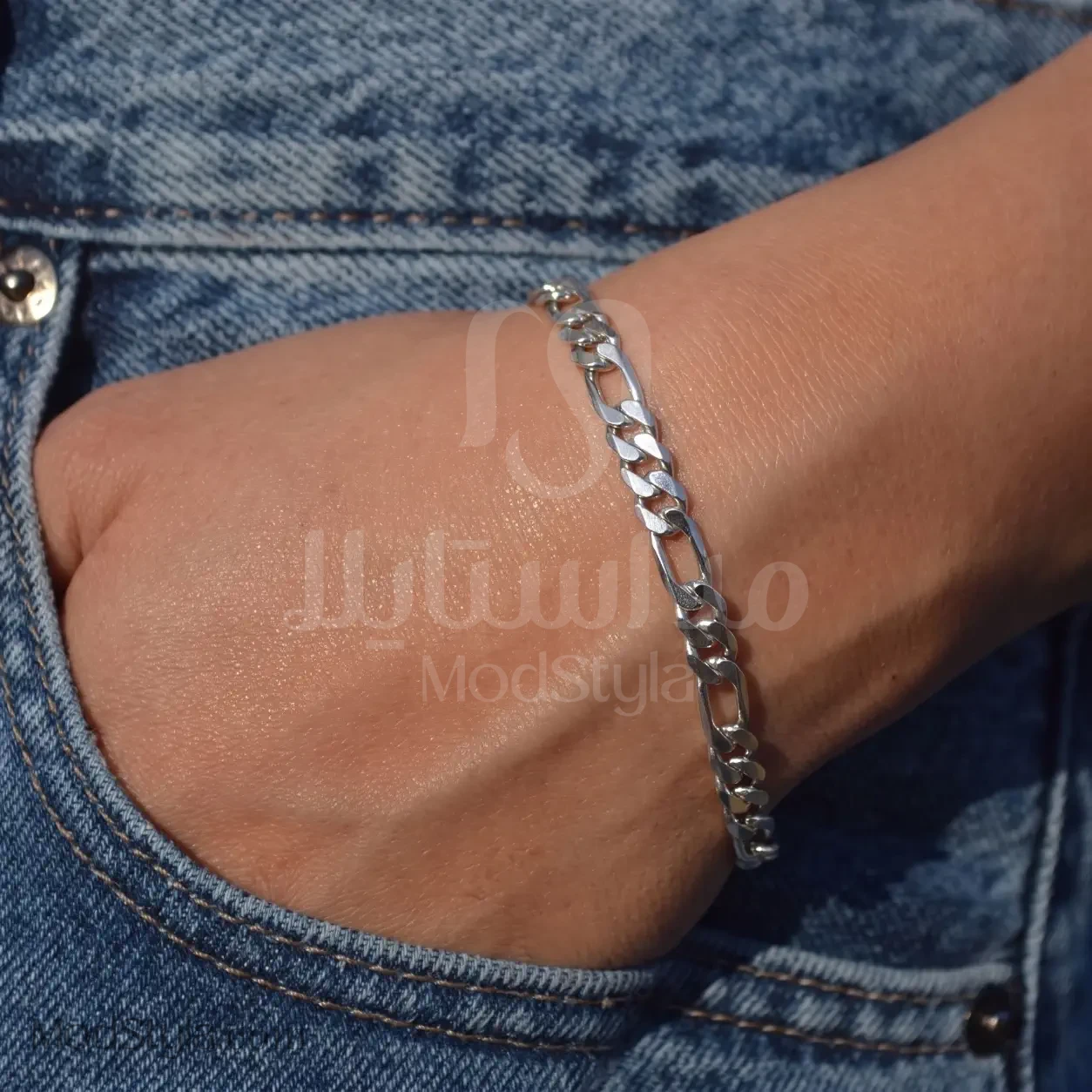 دستبند زنجیر فیگارو نقره‌ای روی مچ دست