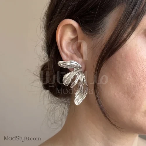 نمای نزدیک گوشواره برگ انتزاعی نقره‌ای