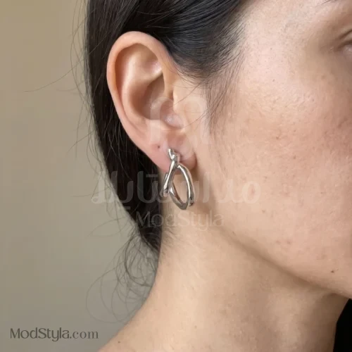 نمای نزدیک گوشواره میخی نقره‌ای با طرح گره حلقه‌ای