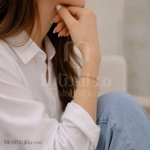 دستبند زنجیری فیگارو ژوپینگ طلایی روی مچ مدل در استایل کژوال