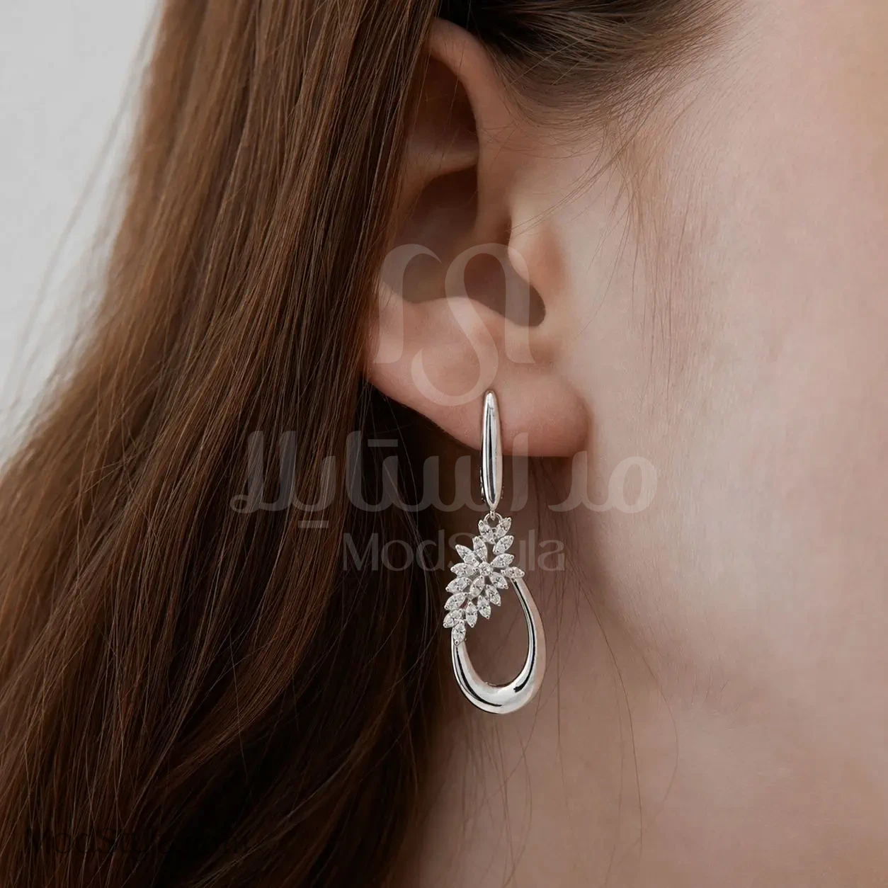 گوشواره اشکی گل‌وبرگ نگین‌دار نقره‌ای روی گوش مدل