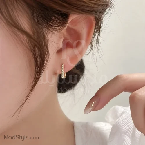 گوشواره حلقه‌ای مستطیلی طلایی روی گوش مدل